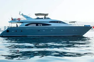 The grey-hulled 2017 Azimut 85 on calm water with the coastline in the distance