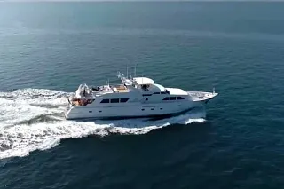 Aerial view of the Custom 103 cruising at speed and leaving a long white wake