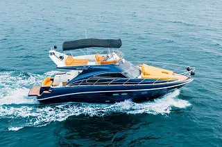 El Custom 45 navegando sobre el mar azul, con casco azul marino y cojines naranjas