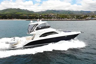 El Sea Ray 52 navegando a buena velocidad frente a la marina y montañas verdes