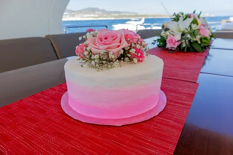Pastel decorado con rosas sobre la mesa de un yate