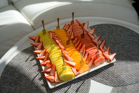 Charola de fruta fresca con fresas, mango y melón servida a bordo