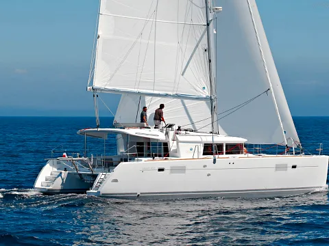 Catamarán de vela navegando con las velas desplegadas en mar abierto