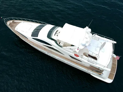 Vista aérea de un yate con flybridge navegando sobre aguas profundas